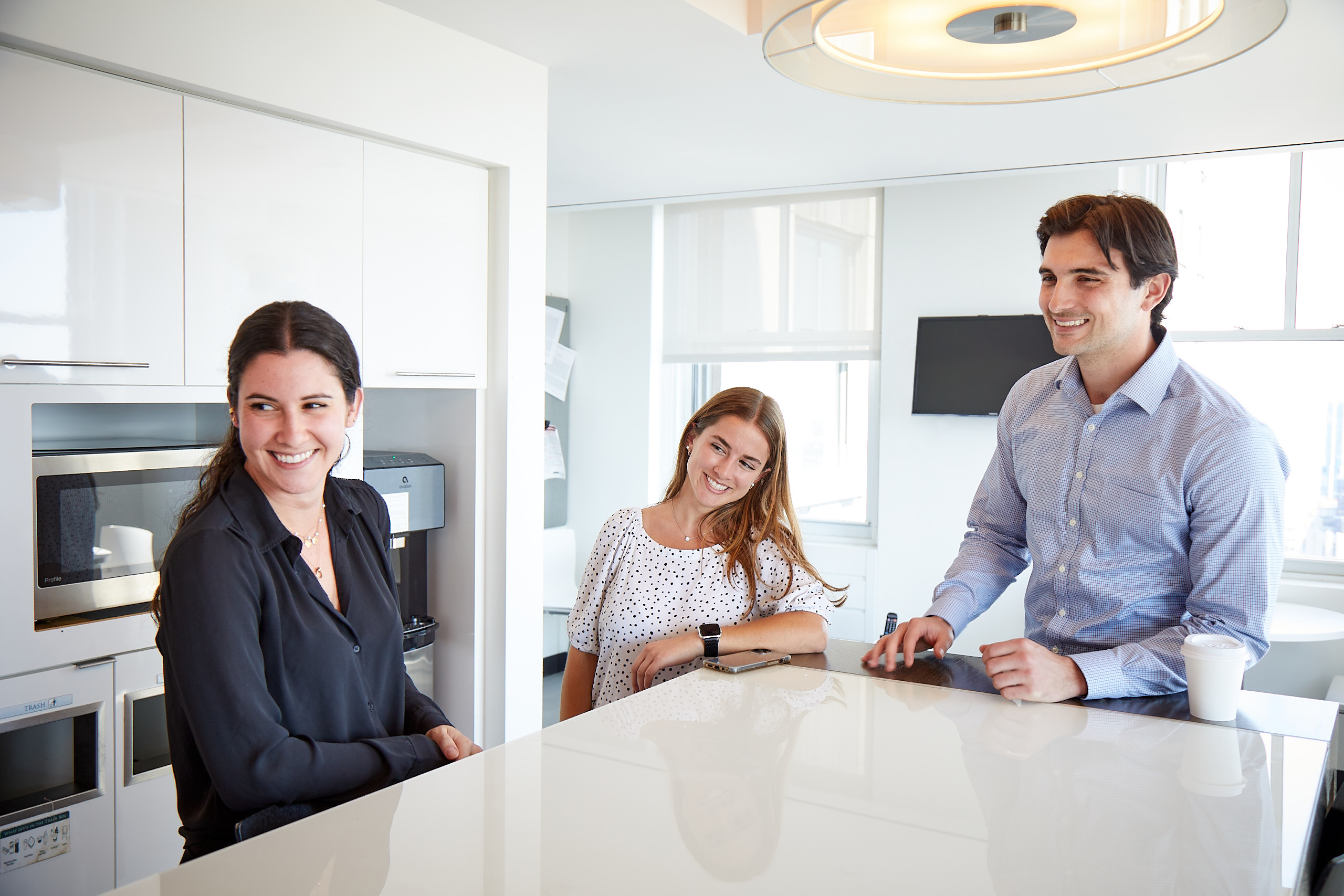 2 Female 1 Male Lazard Colleagues in Pantry Laughing